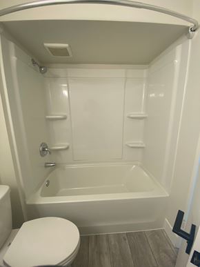 Nanaimo apartment for rent - A white toilet is next to a bathtub in a small bathroom.