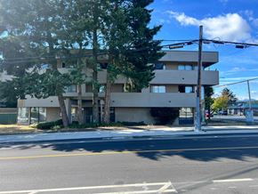 Nanaimo apartment for rent - A street view of a multi-story building with a clear sky above.