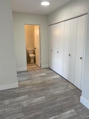 Nanaimo apartment for rent - A bathroom with a toilet and a row of white cupboards.