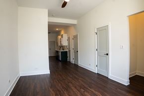 Chicago apartment for rent - A room with white walls and wood flooring with a white door and a white cabinet.