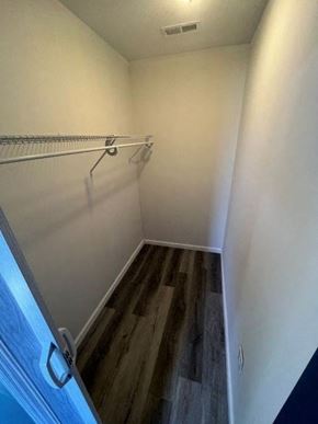 Medina house for rent - A walk in closet with a white wall and a wooden floor.