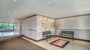 Ottawa apartment for rent - A hallway with a stone wall and a bench.