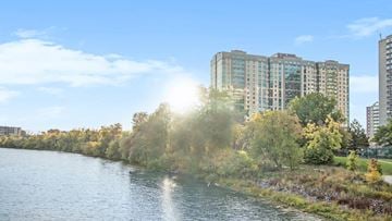 Ottawa apartment for rent - A river flows through a city with trees and buildings on the side.