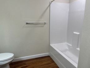 Paris apartment for rent - A white toilet sits next to a white bathtub in a small bathroom.