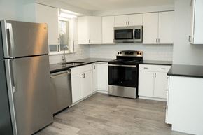 Niagara Falls apartment for rent - a kitchen with stainless steel appliances and white cabinets