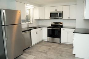 Niagara Falls apartment for rent - a kitchen with stainless steel appliances and white cabinets