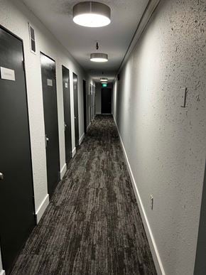 Nanaimo apartment for rent - A long hallway with doors on the left and a light at the end.