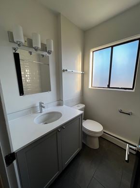 Nanaimo apartment for rent - A bathroom with a sink, toilet, and a window.