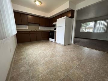 Longview apartment for rent - an empty kitchen with a refrigerator and a window
