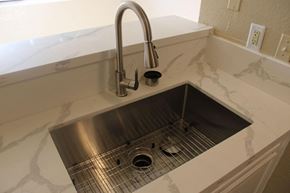 Houston apartment for rent - a stainless steel sink with a chrome faucet in a white counter top