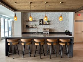 Fargo apartment for rent - a kitchen with wooden stools in front of a counter with lamps and a counter