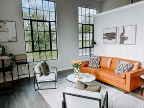 Perkasie apartment for rent - a living room with a orange couch and chairs and large windows