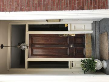 Boston apartment for rent - A brown door with a gold handle is in the center of a white frame.