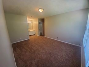 Fayetteville house for rent - a empty living room with carpeting and a bathroom