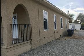 San Bernardino apartment for rent - A building with a white door and windows with a black railing.