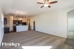 Cleveland house for rent - A spacious living room with a carpeted floor and a ceiling fan.