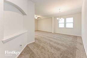 Cleveland house for rent - A spacious room with a carpeted floor and a chandelier hanging from the ceiling.