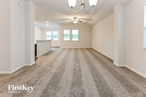 Cleveland house for rent - A spacious room with a carpeted floor and a chandelier hanging from the ceiling.