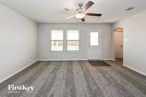 Splendora house for rent - A spacious empty room with a carpeted floor and a ceiling fan.