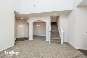 Splendora house for rent - A spacious, empty room with a staircase leading to the second floor.