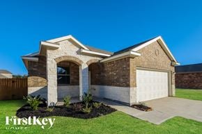 Splendora house for rent - A house with a white garage door and a stone archway entrance.