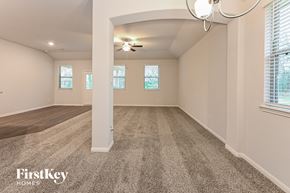 Cleveland house for rent - an empty living room with a ceiling fan and windows