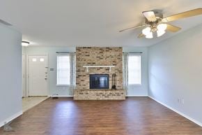 Abilene house for rent - A living room with a fireplace and a ceiling fan.