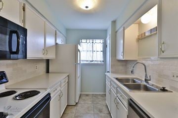 Abilene house for rent - A kitchen with white cabinets and a black microwave.