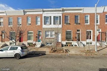 Baltimore house for rent - a white car parked in front of a brick building