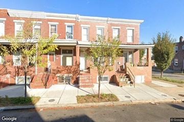 Baltimore house for rent - a brick building with a sidewalk in front of it