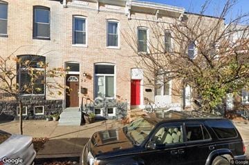 Baltimore house for rent - a black car parked in front of a brick house