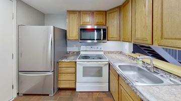 Aurora house for rent - a kitchen with stainless steel appliances and wooden cabinets