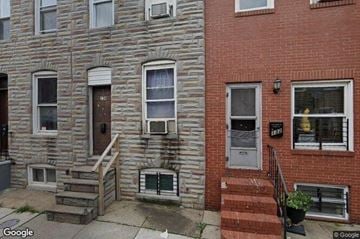Baltimore house for rent - a brick building with stairs and a door