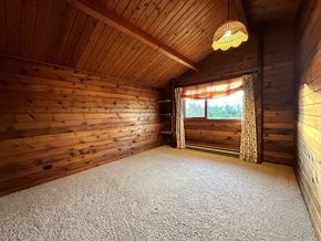 Sitka house for rent - the interior of a log cabin with a carpeted floor