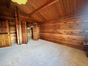 Sitka house for rent - a bedroom with a carpeted floor and wooden walls