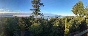 Sitka house for rent - a view of the lake and trees from a balcony