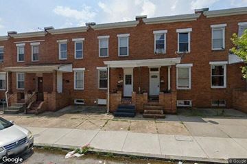 Baltimore house for rent - a brick building with a sidewalk in front of it
