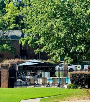 Dunwoody apartment for rent - A pool area with a table and chairs under a canopy.