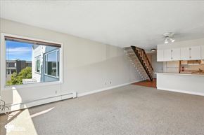 Anchorage apartment for rent - A spacious living room with a staircase leading to the upper floor.