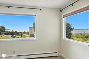 Anchorage apartment for rent - A room with two windows overlooking a parking lot and a building.