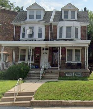 Philadelphia apartment for rent - the front of a brick house with a porch and stairs