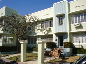 Miami Beach apartment for rent - A white and green building with a tree in front.