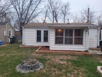 Lakeshore house for rent - a small white tiny house in a backyard with a patio