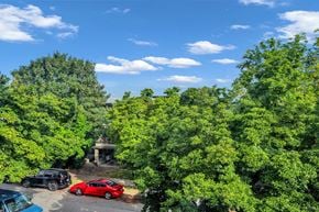 Vancouver apartment for rent - A red car is parked in a driveway surrounded by green trees.