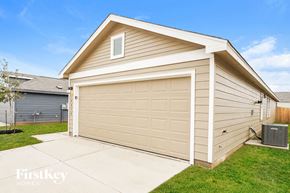 San Antonio house for rent - A garage with a tan siding and a white door is shown.