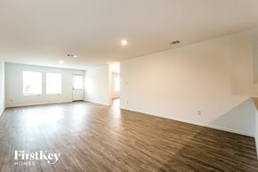 San Antonio house for rent - A spacious room with wooden flooring and white walls, with a window on the left side.
