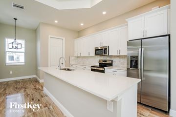 Lehigh Acres house for rent - A kitchen with a stainless steel refrigerator and white countertops.