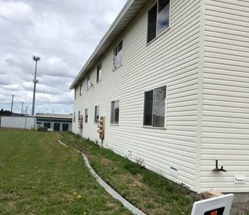 Spokane Valley apartment for rent - A white building with a sign in front of it.