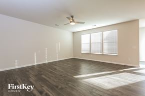 Greer house for rent - A spacious room with wooden flooring and a ceiling fan.