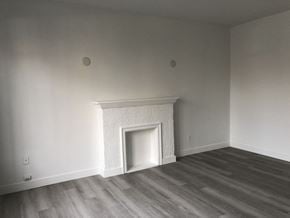 Vancouver apartment for rent - a room with white walls and a fireplace and wooden floors